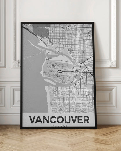 A modern, black and white framed art print of a city map of Vancouver. The map features a stylized layout of roads, rivers, and the coastline, including what appears to be an airport. The word 'VANCOUVER' is displayed in bold, capital letters at the bottom. Poster