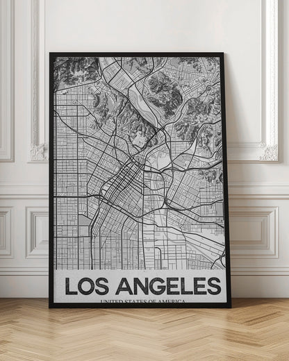 A modern, framed black and white map of Los Angeles. The detailed illustration features a dense grid of city streets, winding highways, rivers, and topographic details of hills. A white banner at the bottom displays the words 'LOS ANGELES' in a bold, black, textured font. Poster