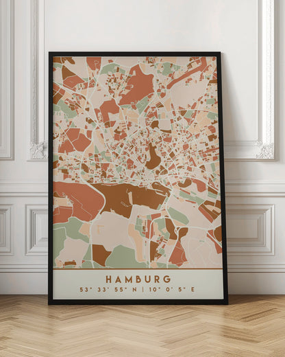 A modern, stylized art print of a Hamburg city map, featuring an abstract pattern of streets and neighborhoods in a color palette of terracotta, brown, sage green, and cream. The bottom of the print has a cream border with the city's name 'HAMBURG' and its geographical coordinates. The artwork is presented in a thin black frame. Wall Art