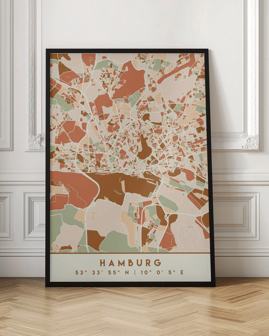 A modern, stylized art print of a Hamburg city map, featuring an abstract pattern of streets and neighborhoods in a color palette of terracotta, brown, sage green, and cream. The bottom of the print has a cream border with the city's name 'HAMBURG' and its geographical coordinates. The artwork is presented in a thin black frame. Wall Art
