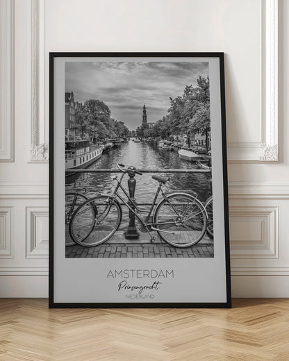 A black and white poster of the Prinsengracht canal in Amsterdam. A bicycle is parked on a bridge in the foreground, overlooking the canal lined with houseboats, trees, and traditional Dutch buildings. The Westerkerk church tower is visible in the distance. The poster has a white border with the words 'AMSTERDAM', 'Prinsengracht', and 'NEDERLAND' at the bottom. Poster