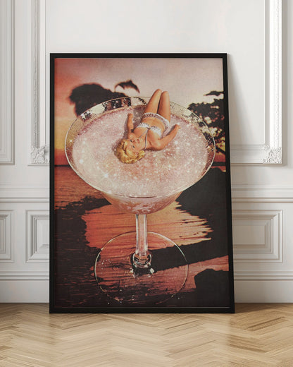 A surreal collage featuring a blonde woman in a white bikini lounging in a giant cocktail glass filled with a sparkling pink liquid, set against a warm sunset over the ocean. Print