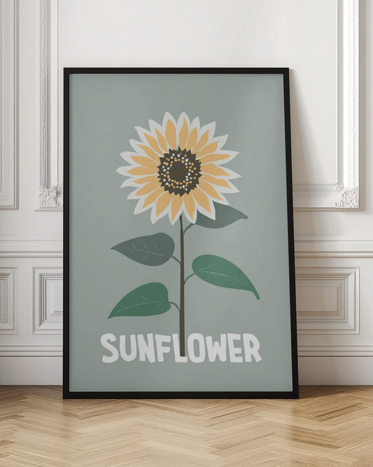 A stylized illustration of a single sunflower against a muted sage green background. The flower has yellow and white petals, a dark brown center, and a thin brown stem with green leaves. At the bottom, the word 'SUNFLOWER' is written in a bold, white, sans-serif font. The artwork is presented within a simple black frame. Decor