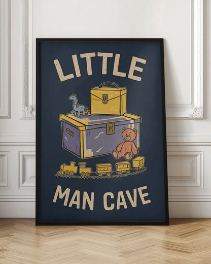 A framed vintage-style illustration with the text 'LITTLE MAN CAVE' on a dark blue background. The artwork features classic toys, including a toy chest, a teddy bear, a toy train on tracks, and a small horse on wheels. Decor