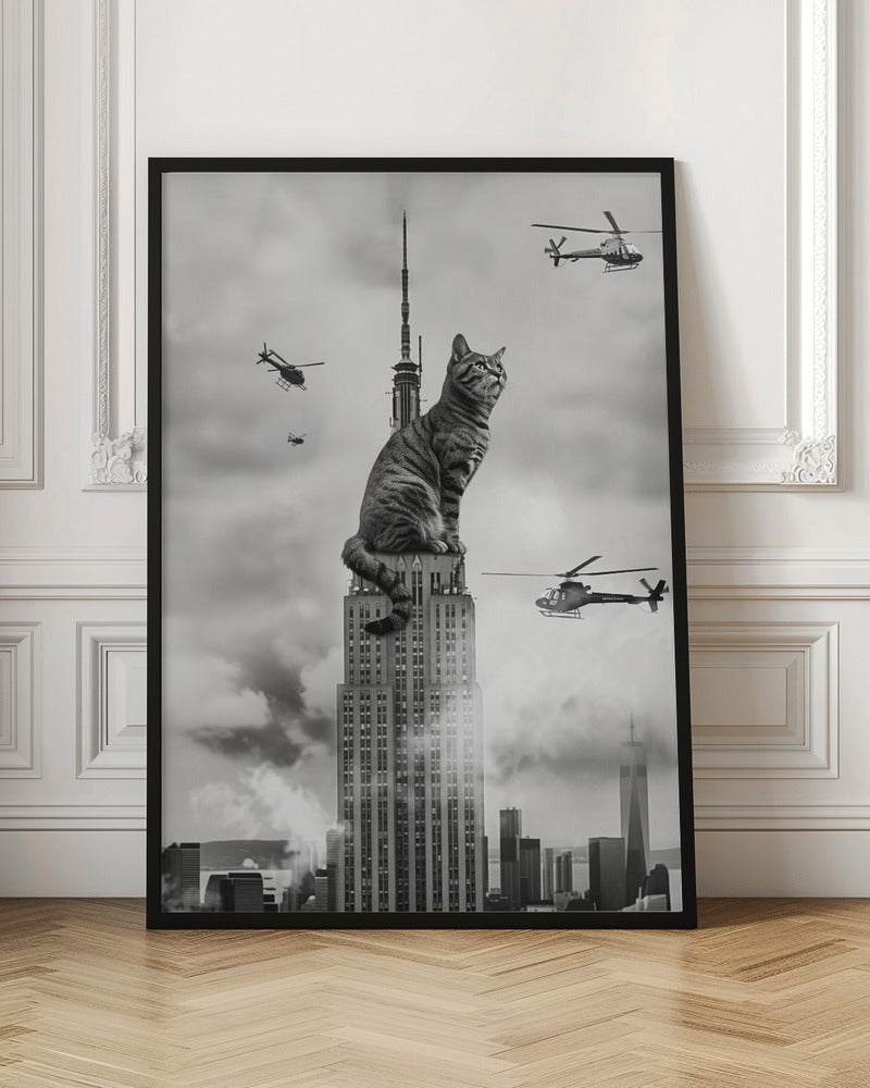 A surreal black and white image depicting a giant tabby cat sitting on top of the Empire State Building, similar to King Kong. Helicopters fly around the colossal cat against a cloudy New York City skyline. Decor