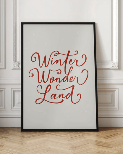 A holiday-themed art print with the words 'Winter Wonder Land' written in a flowing red script font on a speckled, off-white background, all enclosed within a simple black frame. Artwork