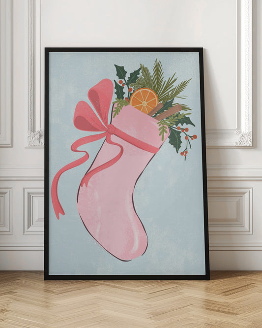 A festive illustration of a pink Christmas stocking against a light blue textured background. The stocking is tied with a large pink ribbon and is filled with holiday greenery, including holly with red berries, pine needles, a slice of dried orange, and cinnamon sticks. Decor