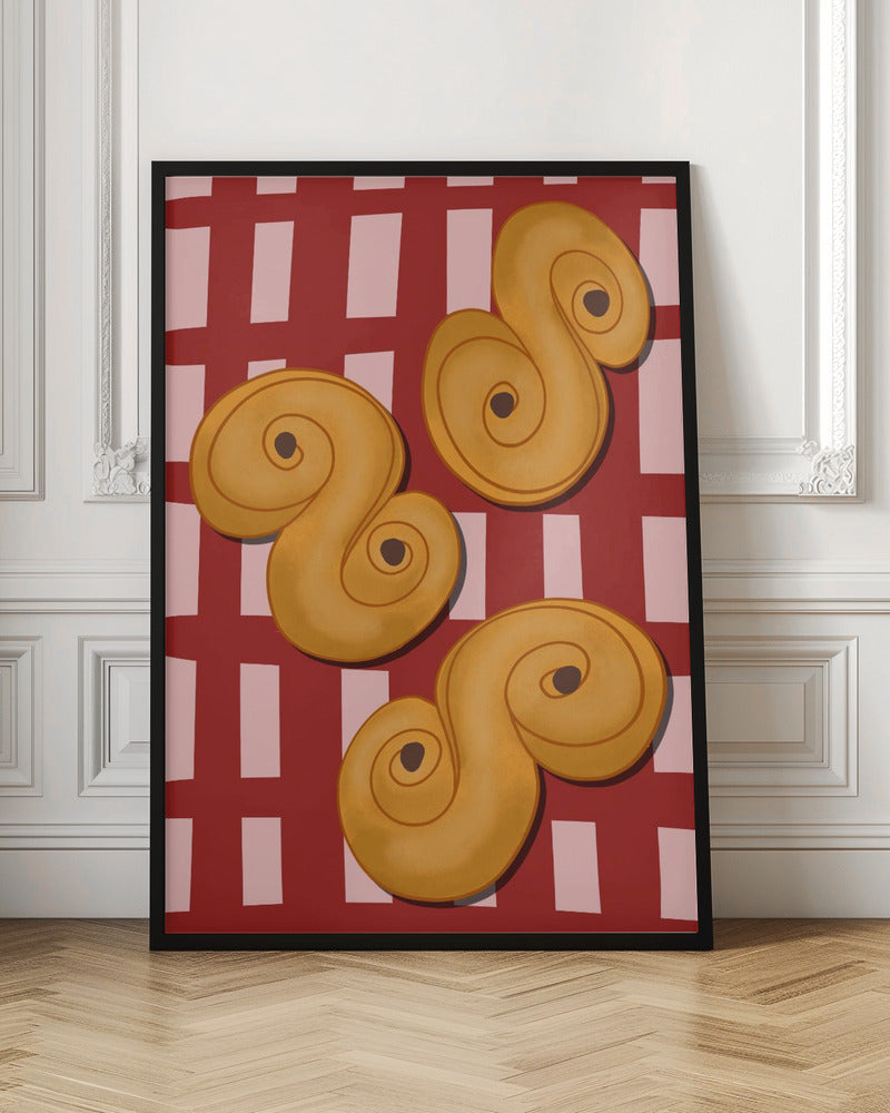 A vibrant illustration of three golden-yellow S-shaped pastries, resembling Swedish saffron buns, resting on a red and pink checkered tablecloth. The artwork is presented within a black frame. Decor