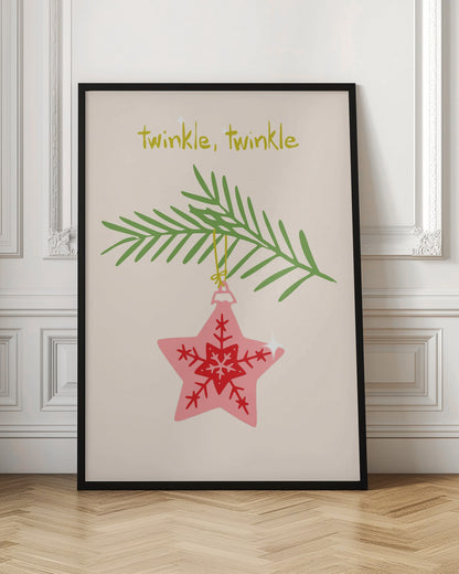A framed piece of art with a light cream background featuring the words 'twinkle, twinkle' in a playful yellow-green font. Below the text, a pink star-shaped Christmas ornament with red snowflake designs hangs from a green pine branch. Print