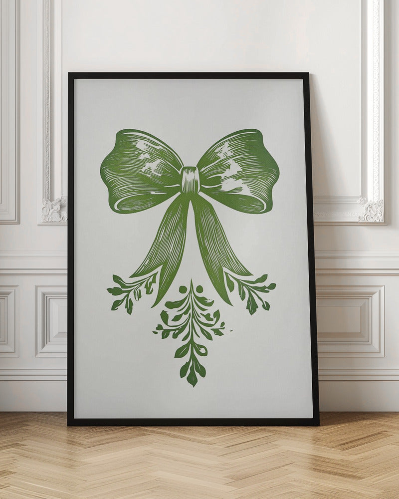 A vintage-style linocut print of a large green bow with leafy accents on a white background, enclosed in a thin black frame. The bow is detailed with lines suggesting texture and shadow, and foliage hangs from its ribbons. Artwork