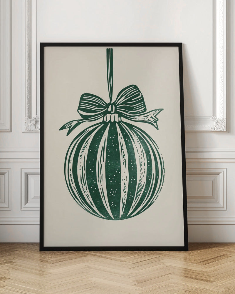 A vintage-style linocut print of a dark green Christmas bauble with a large bow, hanging against a cream background. The ornament features vertical stripes and white speckles, and the entire artwork is presented in a simple black frame. Artwork