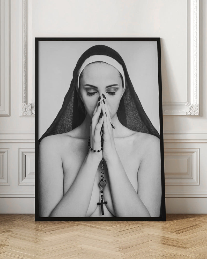 A black and white portrait of a woman with dramatic eye makeup wearing a nun's habit. Her eyes are closed and her hands are clasped in front of her face in prayer, holding a black rosary. Her shoulders are bare, creating a stark contrast. Artwork
