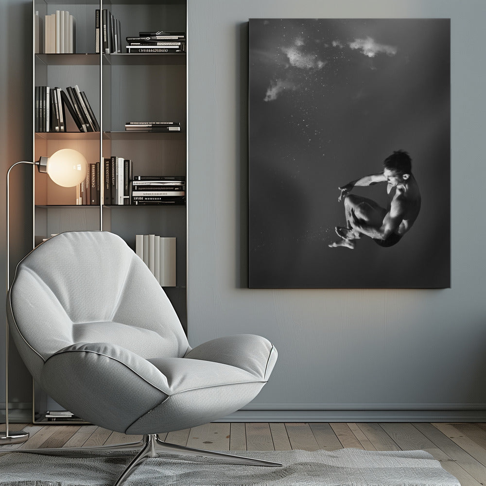 A dramatic black and white photograph of a male diver suspended mid-air in a tuck position. The background is a dark, atmospheric gray, with what appears to be clouds and bubbles, giving the impression of being underwater or in a vast, empty space. The lighting highlights the athlete's muscular physique. Artwork