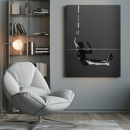 A dramatic black and white photograph of a male pole vaulter in mid-air, successfully clearing the horizontal bar. The athlete's body is parallel to the ground, with one arm still holding the vertical pole, against a solid gray sky. The image is enclosed in a simple black frame. Artwork