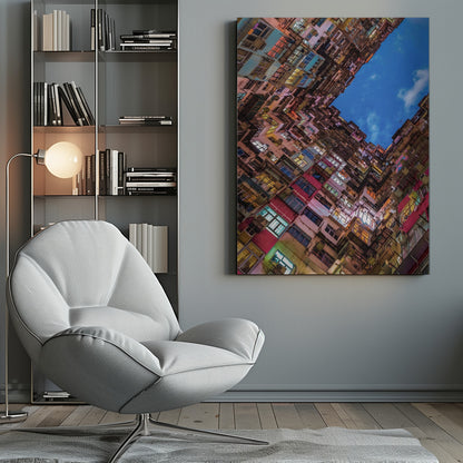 A dramatic worm's-eye view looking up at colorful, densely packed high-rise apartment buildings that create a geometric frame around a patch of deep blue sky. Wall Art