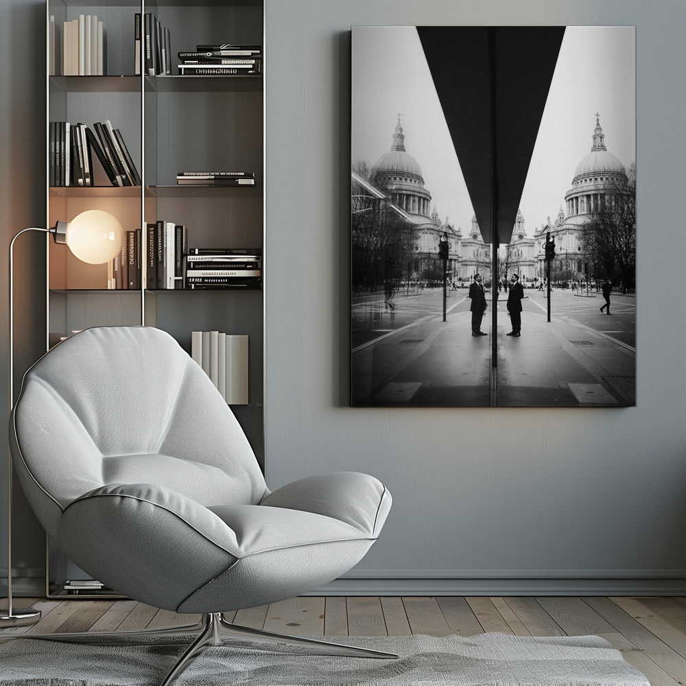 A surreal black and white photograph capturing a symmetrical reflection of a city scene, with St. Paul's Cathedral prominently featured on both sides. A dark, V-shaped reflection from a building divides the image vertically. In the foreground, the reflection of two men in dark suits standing on the sidewalk adds a human element to the grand architectural view. Decor