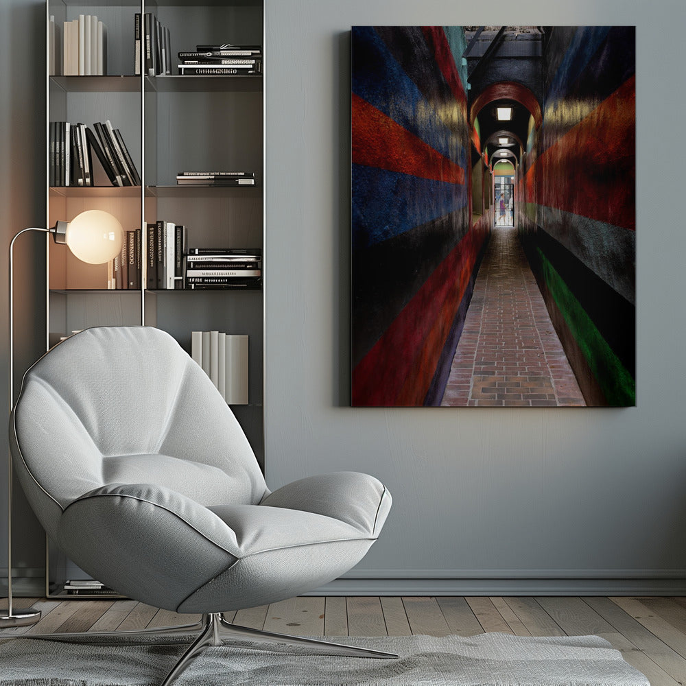A long, narrow brick alleyway viewed from a one-point perspective, with walls painted in wide, colorful horizontal stripes of red, blue, and black, leading to a distant, sunlit exit where a person stands. Wall Art