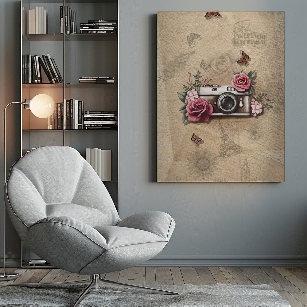 A vintage-style collage art piece in a black frame. The central focus is a retro camera adorned with pink and magenta roses and green leaves. The background is a sepia-toned collage of old newspaper or book pages, with faint illustrations of European landmarks like the Colosseum and the Eiffel Tower, along with butterflies and flowers. Poster