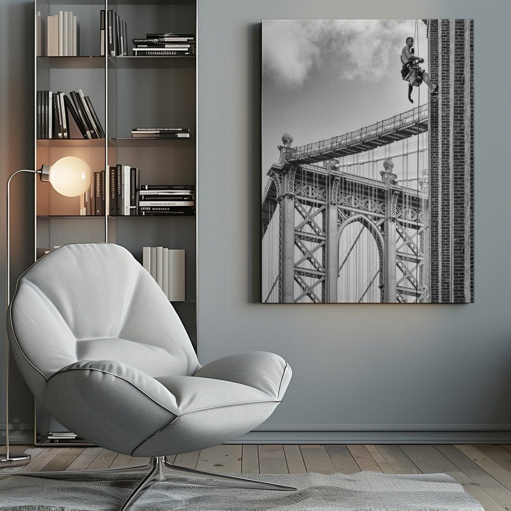 A black and white photograph capturing a window washer rappelling down the side of a tall brick building. In the background, the intricate steel structure of the Manhattan Bridge stands against a partly cloudy sky, creating a powerful urban scene. Decor