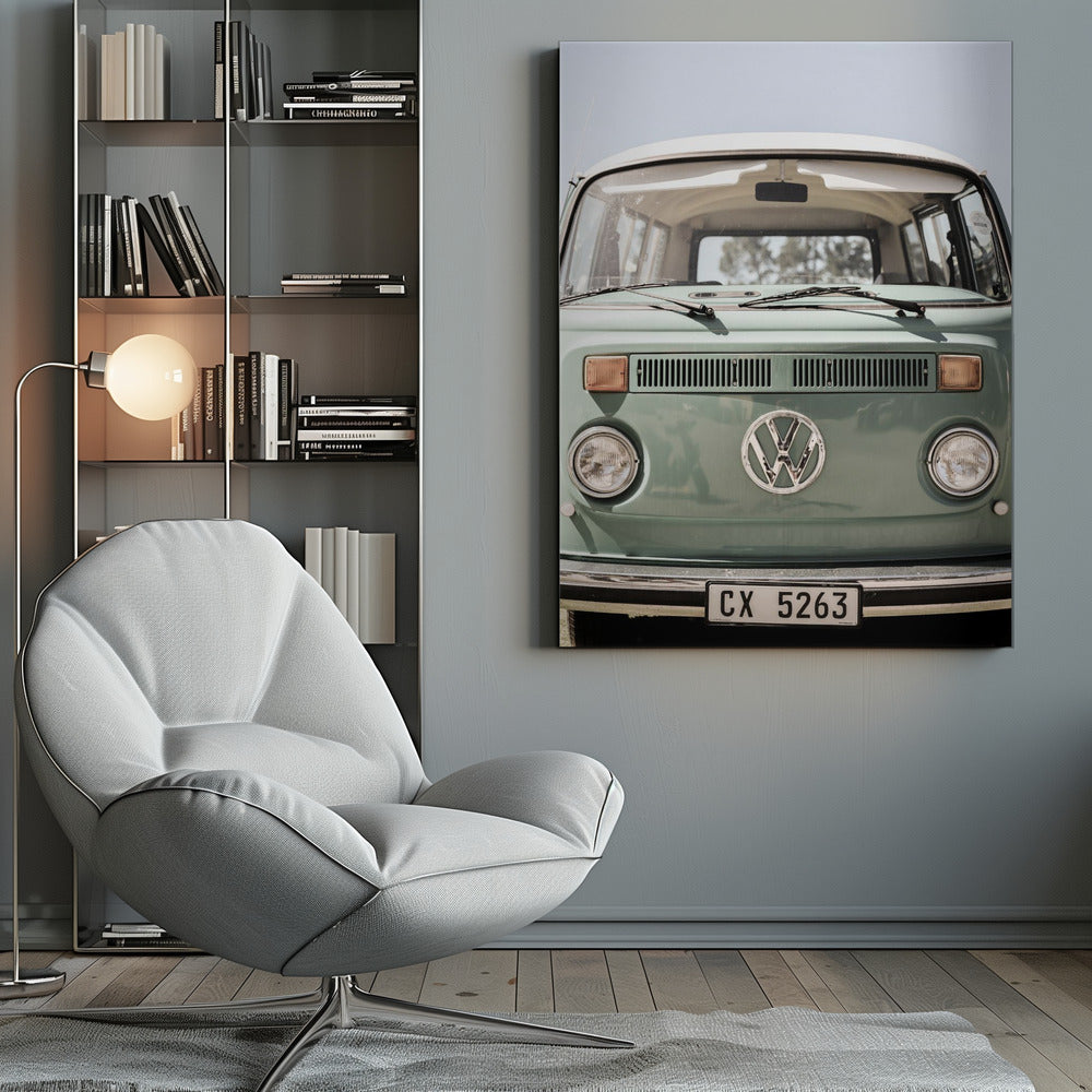 A close-up front view of a vintage sage green Volkswagen bus with a white roof. The iconic VW logo is on the front, with round headlights and a European license plate, set against a pale blue sky. Print