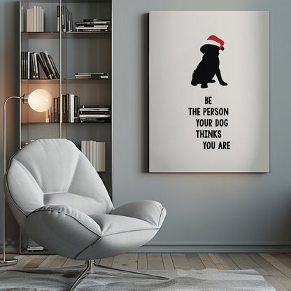 A framed art print featuring a black silhouette of a dog wearing a red Santa hat on an off-white background. Below the dog is the motivational quote, 'BE THE PERSON YOUR DOG THINKS YOU ARE' in black block letters. Decor