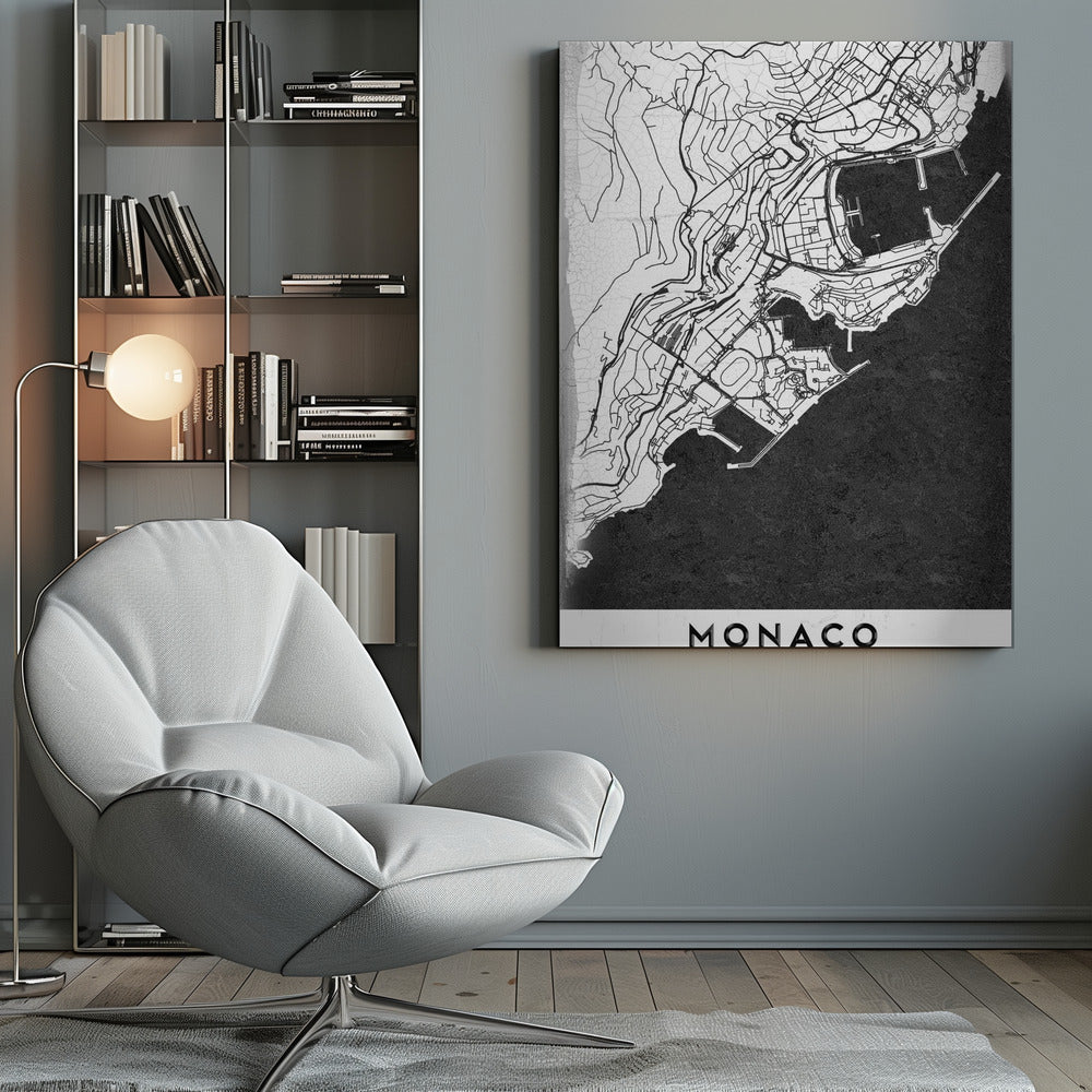 A modern black and white map of Monaco, presented as a framed poster. The map details the city's streets and coastline in black lines on a white background, while the sea is depicted in a solid, textured black. The title 'MONACO' is at the bottom in a bold, white band. Poster