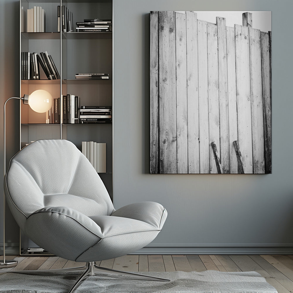 A black and white, low-angle photograph of a weathered wooden plank fence. The vertical planks are of varying heights, creating an uneven top line against a pale sky. The focus is on the texture of the wood, showing prominent grain, knots, and nail holes, all framed in black. Poster