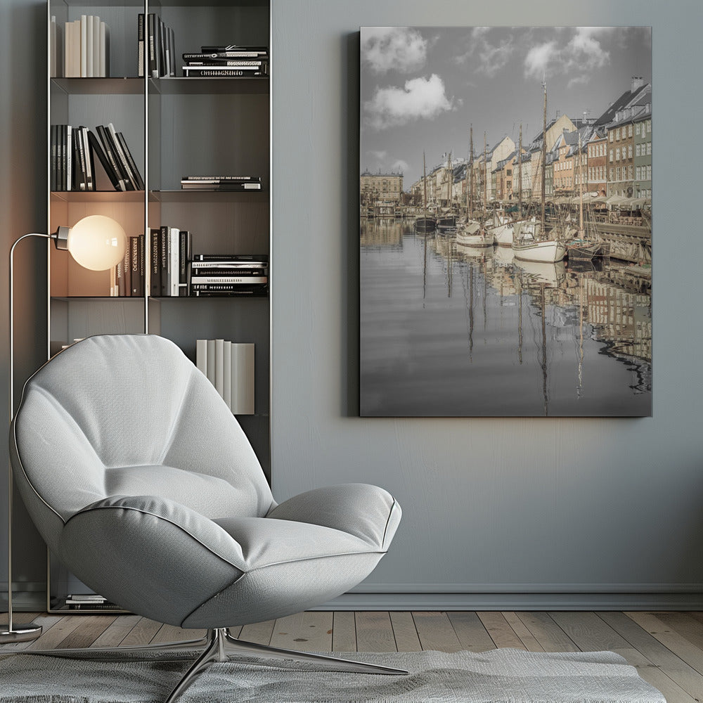 A muted, desaturated photograph of the Nyhavn harbor in Copenhagen. Old-fashioned sailboats are moored along the canal in front of a row of colorful historic buildings. The boats, buildings, and a cloudy sky are perfectly reflected in the calm water. Wall Art