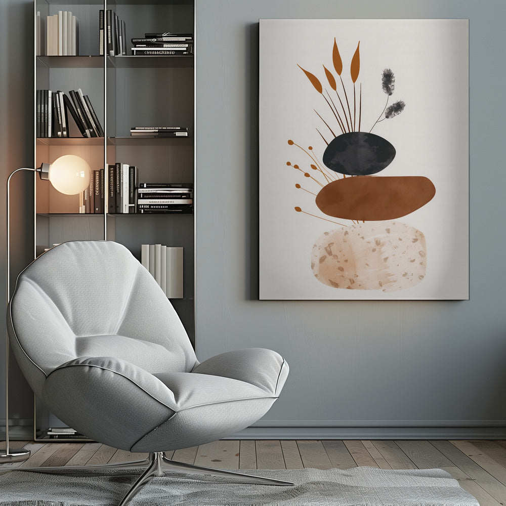 A minimalist abstract artwork featuring a stack of three organic, stone-like shapes against an off-white background, framed in black. The bottom shape is a speckled beige, the middle is a solid terracotta brown, and the top is a textured charcoal black. Various stylized botanical elements, including brown reeds and black fuzzy stems, emerge from behind the stack. Decor