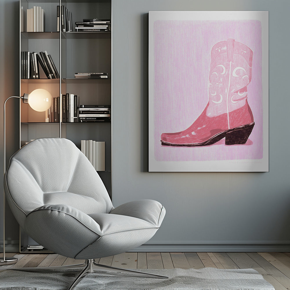 A framed art print of a pink cowboy boot against a light pink, textured background. The boot is illustrated in a block-print style with shades of pink, white decorative inlay patterns of moons and stars, and a dark brown heel and sole. Decor