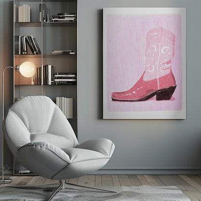 A framed art print of a pink cowboy boot against a light pink, textured background. The boot is illustrated in a block-print style with shades of pink, white decorative inlay patterns of moons and stars, and a dark brown heel and sole. Decor