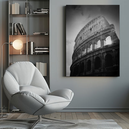 A dramatic, low-angle black and white photograph of the ancient Roman Colosseum. The sun shines brightly through one of the upper archways, creating a lens flare and silhouetting a few birds in flight against the cloudy sky. Poster