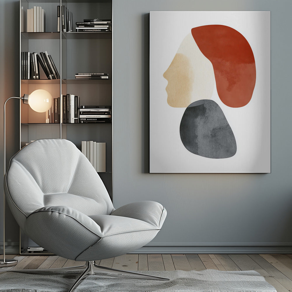A minimalist abstract artwork in a black frame, featuring overlapping shapes that form a stylized human profile. The face is a light beige, topped with a rust-red shape like hair, and a dark grey, stone-like shape is positioned below the chin, all on a white background. Artwork