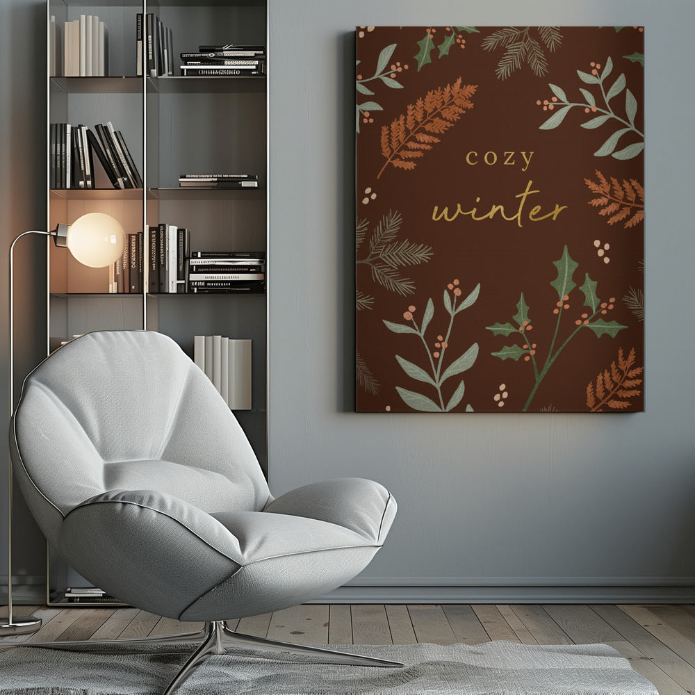 A warm, illustrative poster with a dark brown background featuring the words 'cozy winter' in gold script at the center. The text is framed by a wreath of winter botanicals, including holly, pine needles, and ferns in shades of green and burnt orange. Print