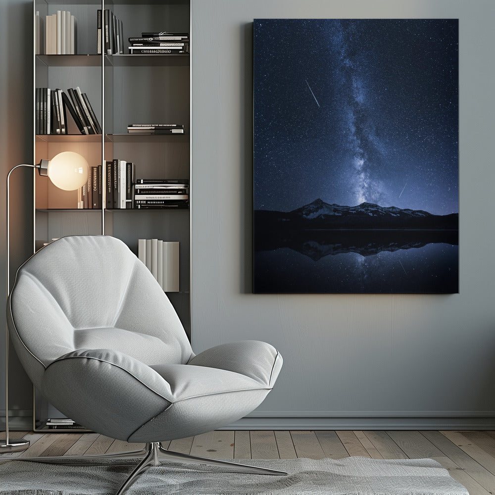 A breathtaking night photograph of the Milky Way galaxy stretching vertically across a deep blue, star-filled sky. Two shooting stars streak through the atmosphere above a dark, snow-dusted mountain range, which is perfectly reflected in the calm, mirror-like surface of a lake in the foreground. Artwork