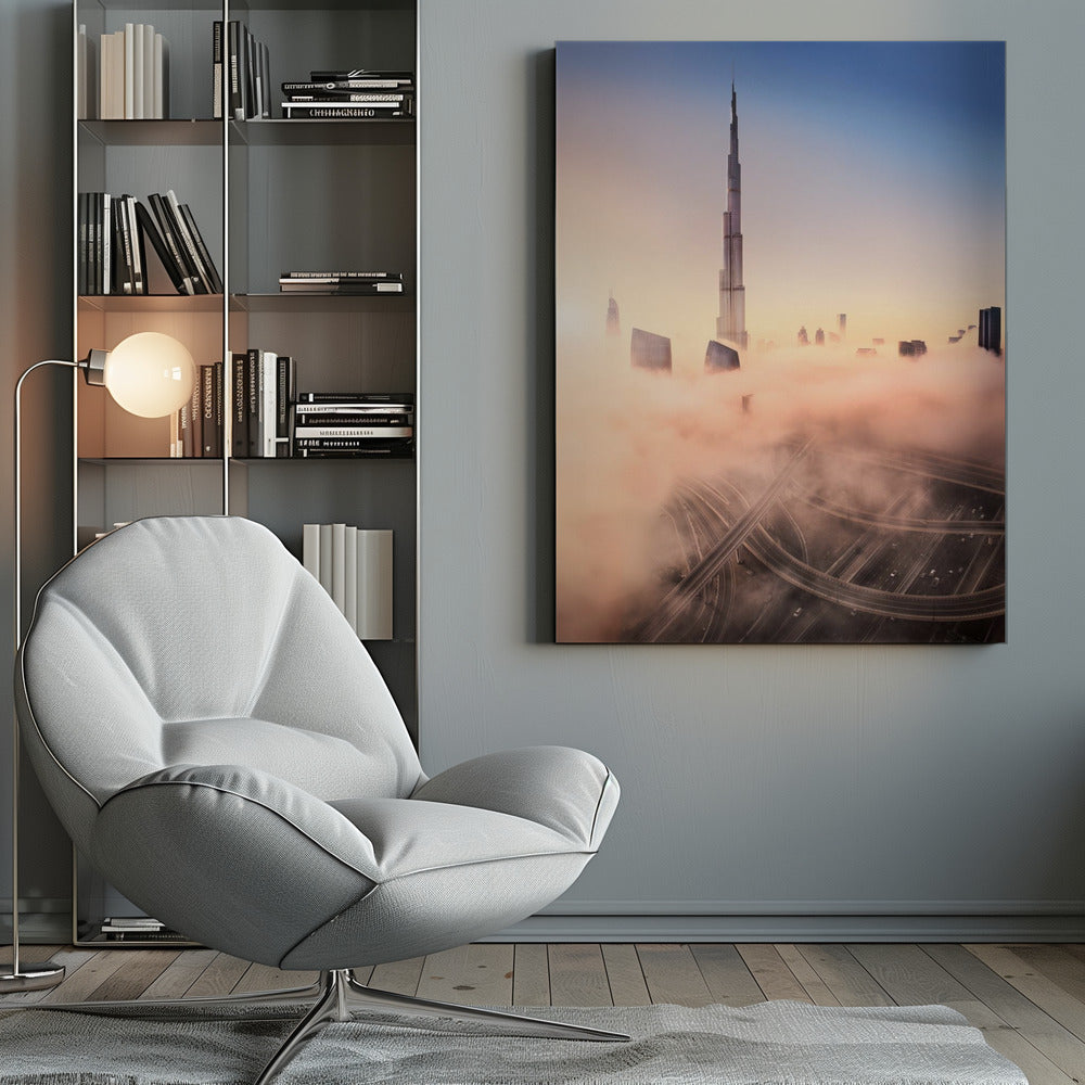 An aerial photograph of the Burj Khalifa in Dubai, towering over a thick blanket of pink and orange-hued fog at sunrise. Below the fog, a complex highway interchange is visible, with the clear blue sky above. Wall Art