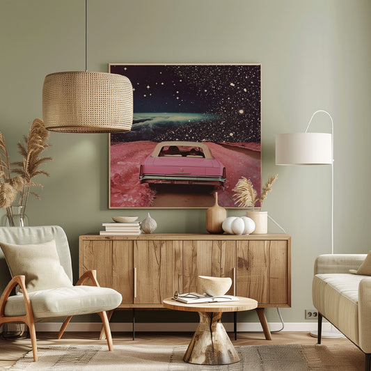 A framed collage-style artwork depicting a vintage pink convertible from behind, driving on a surreal pink road. The background is a vast, dark, star-filled space with a luminous, cloudy planet horizon. Poster