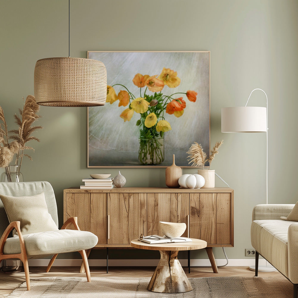 A soft-focus still life photograph of a bouquet of yellow and orange poppies in a clear glass jar, set against a delicate, light green textured background, all enclosed in a light wood frame. Print