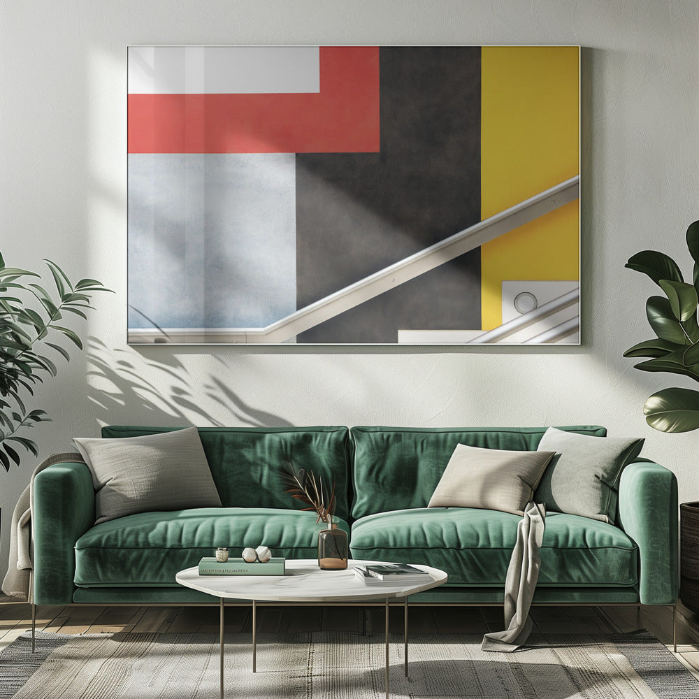 A framed abstract art piece featuring a composition of large, solid-colored geometric shapes in red, yellow, black, white, and light gray. A silver handrail cuts diagonally across the lower portion of the image, adding a sharp line and a sense of architectural space. Artwork