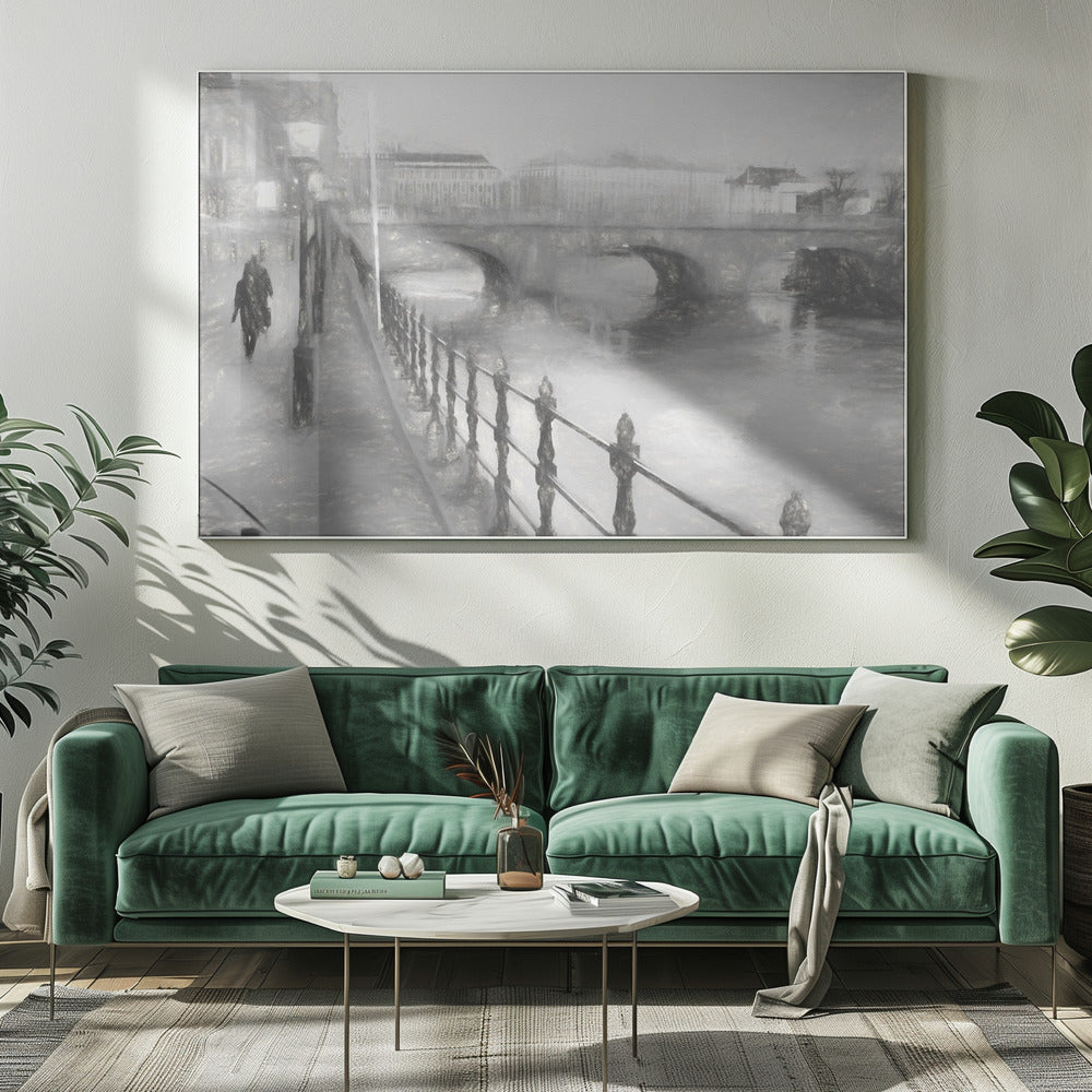 A framed, black and white impressionistic artwork of a city scene on a foggy or rainy day. In the foreground, a dark metal railing runs along a riverside walkway where a person in a dark coat is walking. An arched stone bridge crosses the river in the midground, with hazy buildings visible in the background, creating a moody and atmospheric scene. Wall Art