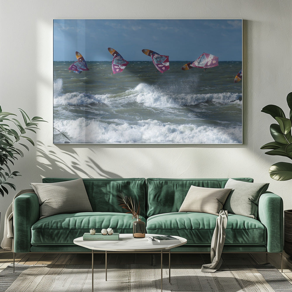A composite, silver-framed photograph capturing the four stages of a windsurfer's impressive jump over choppy, white-capped ocean waves under a partly cloudy blue sky. Print