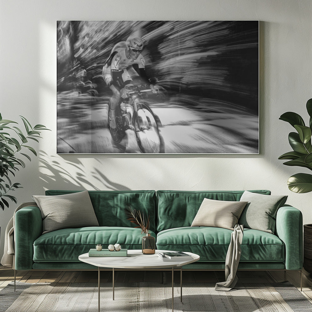 A dramatic black and white action shot of a professional cyclist racing. The cyclist is in focus, wearing a helmet and sunglasses, while the background is a streaky motion blur, creating a powerful sense of speed and movement. The image is enclosed in a silver frame. Wall Art