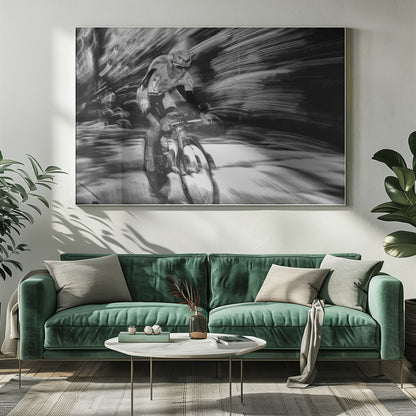 A dramatic black and white action shot of a professional cyclist racing. The cyclist is in focus, wearing a helmet and sunglasses, while the background is a streaky motion blur, creating a powerful sense of speed and movement. The image is enclosed in a silver frame. Wall Art