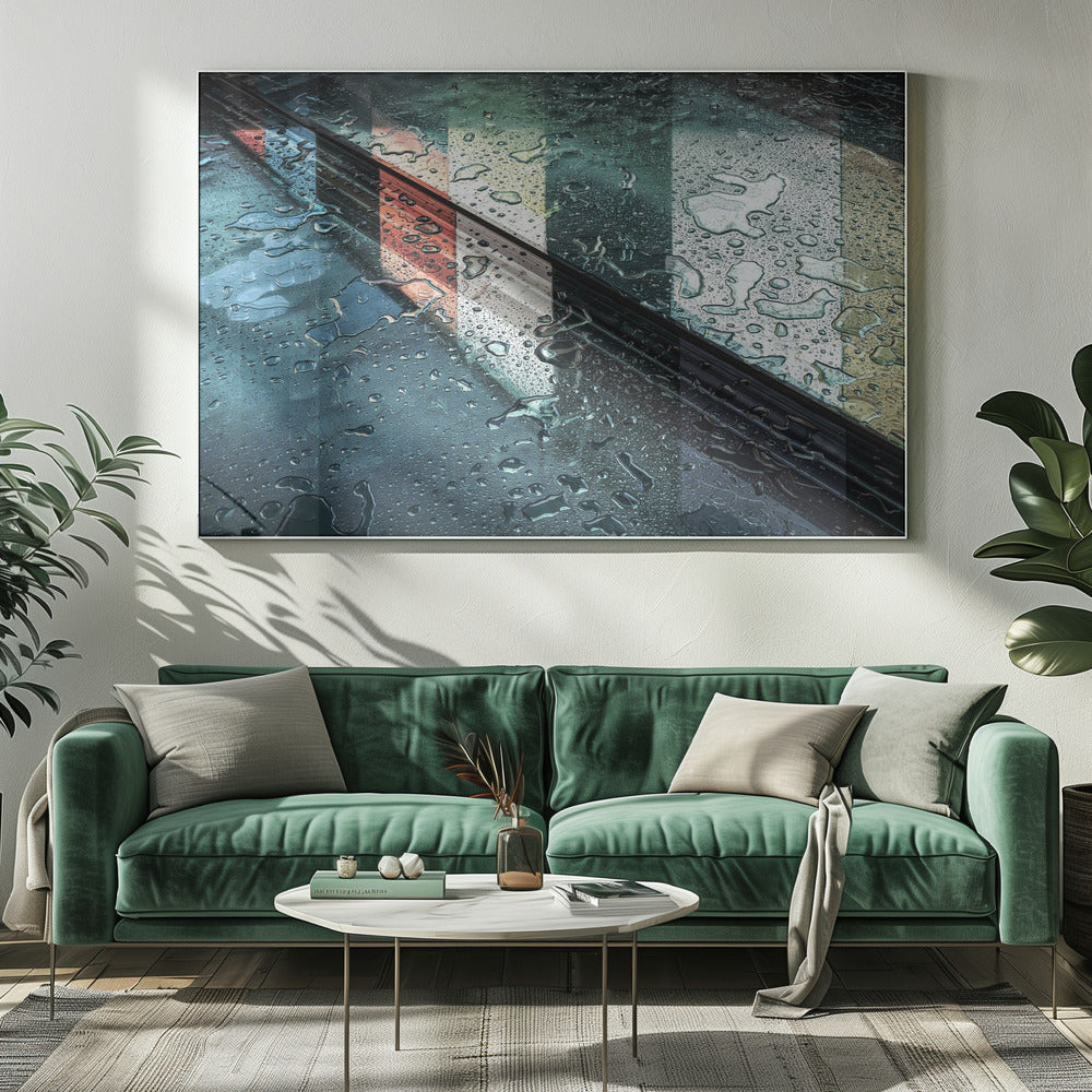 An abstract close-up photograph of a wet, dark surface, possibly a car, covered in raindrops, with a prominent black diagonal line. Colorful vertical stripes of red, cream, and green are reflected on the glossy, wet surface. The artwork is presented in a silver frame. Decor