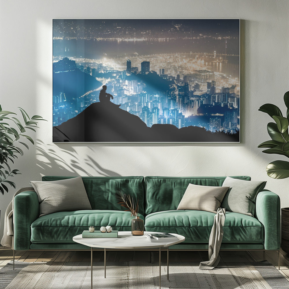 A silhouette of a person sitting on a hilltop, gazing out over a vast, illuminated city skyline at night. The city lights glow in shades of blue and gold against the dark landscape, with a body of water in the distance. Decor