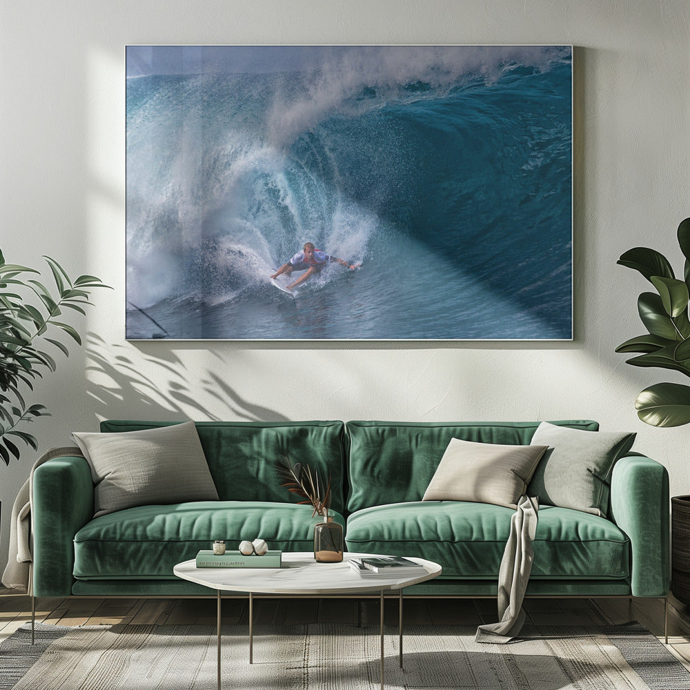A dramatic action shot of a professional surfer skillfully navigating the inside of a massive, curling blue ocean wave, surrounded by white sea spray, all enclosed in a silver frame. Artwork