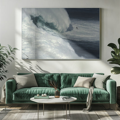 A framed aerial photograph captures a dramatic ocean scene where a lone surfer on a surfboard is dwarfed by an immense, powerful wave cresting nearby, conveying a sense of scale and adventure. Artwork
