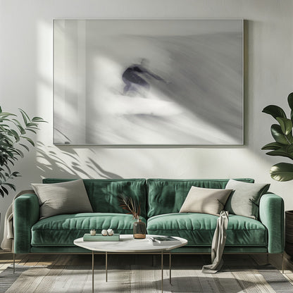 An artistic black and white photograph using motion blur to capture a surfer in a dynamic, fluid pose on a wave. The slow shutter speed creates a sense of speed and abstract movement, with the surfer's dark wetsuit contrasting against the white, streaked water. The image is presented in a silver frame. Decor