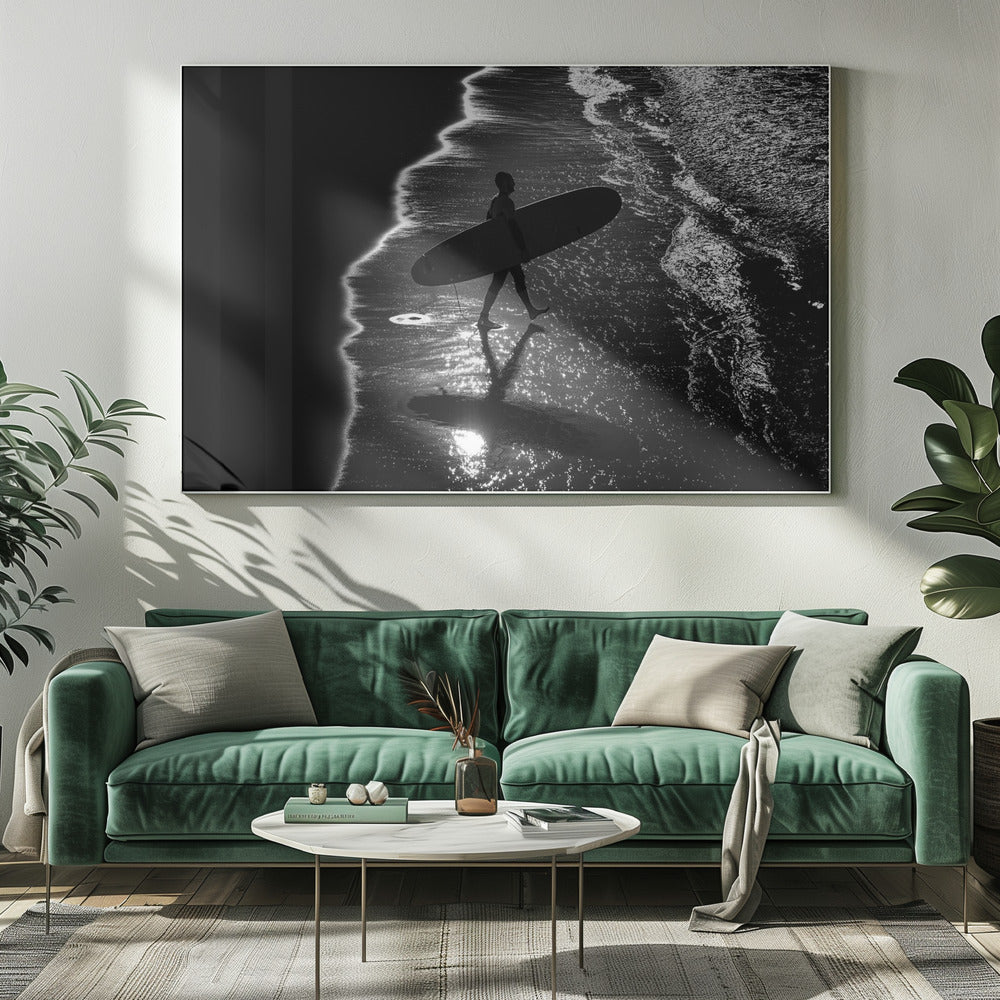 A dramatic, high-contrast, black and white aerial view of a silhouetted surfer carrying their surfboard along the shoreline. The sun glints off the wet sand and the dark water, creating a sparkling effect and a clear reflection of the surfer. Poster