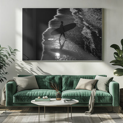 A dramatic, high-contrast, black and white aerial view of a silhouetted surfer carrying their surfboard along the shoreline. The sun glints off the wet sand and the dark water, creating a sparkling effect and a clear reflection of the surfer. Poster